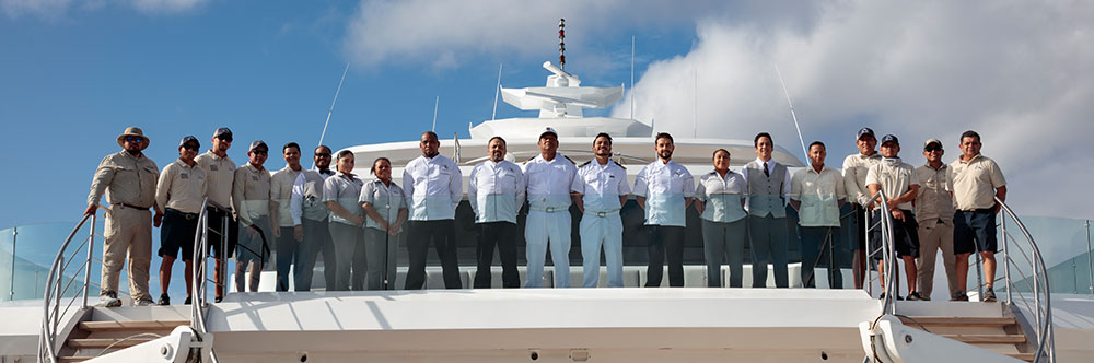 Professional crew members standing on the deck of a luxury Galapagos charter yacht. Hermes Mega Catamaran