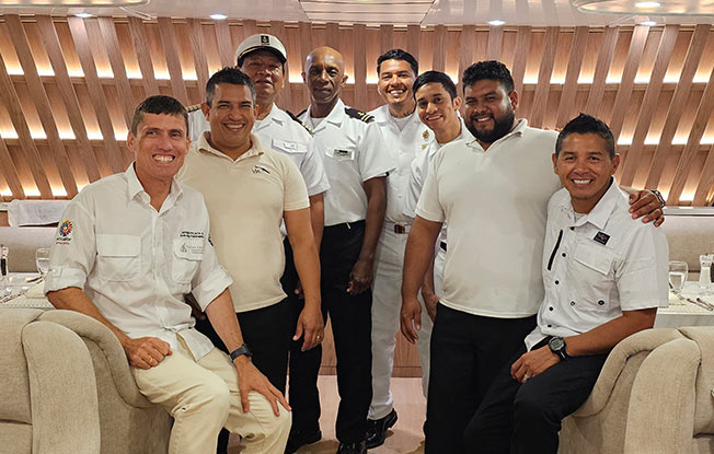 Friendly crew members smiling on the deck of the best Galapagos cruise for personalized service.