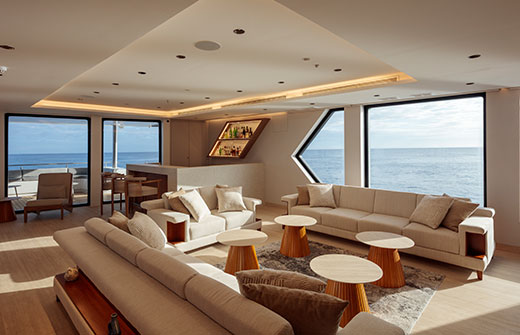 Sophisticated social bar area with ocean views, where expert bartenders serve premium drinks on a Galapagos ultra-luxury cruise.