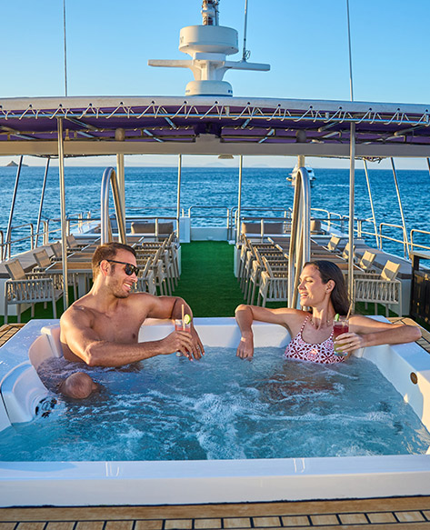 Galapagos Cruise: Monserrat Yacht guests relaxing on sundeck with jacuzzi