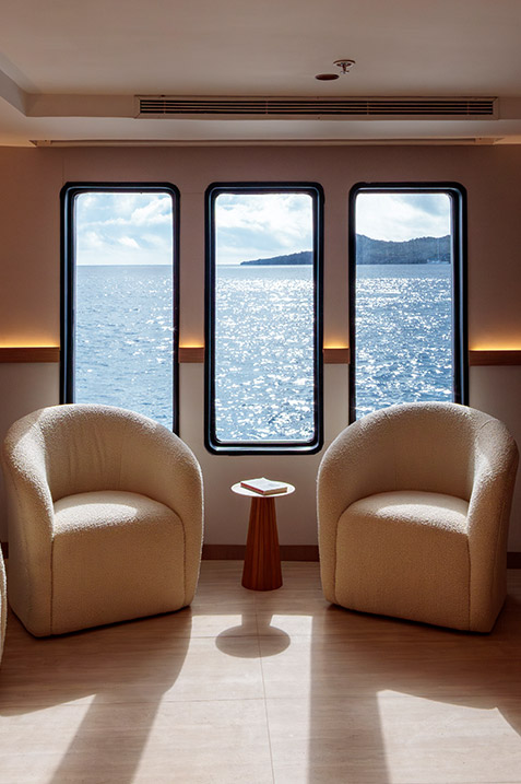Tranquil library and reading room with comfortable seating on the Hermes luxury vessel.
